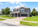 A pristine two-story home sits on a manicured lawn with beautiful landscape and a brick driveway at 15900 Citrus Knoll Dr, Winter Garden, FL 34787