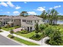 Gorgeous home with a front yard featuring lush landscaping and a serene lake backdrop at 17996 Adrift Rd, Winter Garden, FL 34787