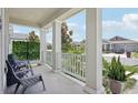 Inviting front porch features white columns and railing, seating, and pleasant neighborhood views at 2345 Volunteer Ave, Kissimmee, FL 34744