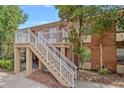 Two-story condo building with brick facade, white railings, and stairway with landscaped surroundings at 2517 Caper Ln # 207, Maitland, FL 32751
