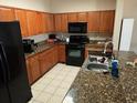 Well-lit kitchen featuring wooden cabinetry and modern black appliances at 2536 Lancien Ct # 5, Orlando, FL 32826