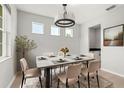 Bright dining room featuring a chandelier, modern table, and minimalist decor for elegant dining at 2541 Leyland Cypress Ln, Sanford, FL 32773