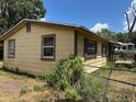 Side view of a yellow single-story home showing standard windows, a small front porch, and a fenced yard at 2601 Tennessee Rd, Lakeland, FL 33815