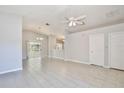 Open-concept living room with neutral paint, tile flooring, ceiling fan, and a partial kitchen view at 2742 Woodruff Dr, Orlando, FL 32837