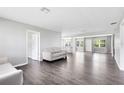 Open-concept living room featuring modern gray walls, laminate flooring, and abundant natural light at 4006 Kasper Dr, Orlando, FL 32806