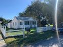Inviting white home featuring a picket fence and lush green lawn at 421 Ohio Ave, St Cloud, FL 34769
