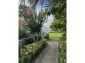 Serene landscaped pathway leading to a lush green lawn, surrounded by vibrant tropical foliage at 4741 Chevy Pl # 149C2L, Orlando, FL 32811