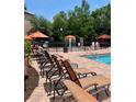 Inviting community pool area with lounge chairs and umbrellas for residents to relax and enjoy at 8010 Tuscany Way # 3102, Davenport, FL 33896