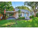 Charming single-story home with a bright blue front door, screened porch, and large front lawn at 815 E 11Th Ave, Mount Dora, FL 32757
