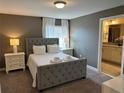 Comfortable bedroom featuring neutral colors, plush carpet, and a connected ensuite bathroom at 8934 Stinger Dr, Davenport, FL 33896