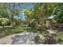 Single story home with mature trees in the front yard providing lots of shade at 905 Flewelling Ave, Ocoee, FL 34761