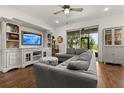 Comfortable living room with a plush sectional sofa, a large window with a view of the backyard, and custom built-ins at 922 Grazie Loop, Davenport, FL 33837