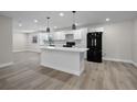 Modern kitchen with a large island, white cabinets, new appliances, and luxury vinyl plank flooring at 1011 W 13Th St, Lakeland, FL 33805