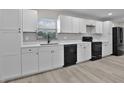 Modern kitchen featuring white cabinets, black appliances, quartz counters, and stylish backsplash at 1011 W 13Th St, Lakeland, FL 33805