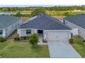 Aerial shot of home with solar panels, manicured front lawn, and a lake in the background at 1159 Mountain Flower Ln, Davenport, FL 33837