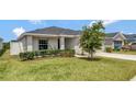 Charming home featuring a well-maintained lawn and manicured shrubs at 1159 Mountain Flower Ln, Davenport, FL 33837