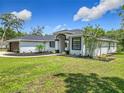 Charming home features a modern exterior with manicured lawn and landscape beds with mulch at 13735 Sw 73Rd St, Ocala, FL 34481