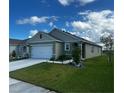 Inviting one-story residence displays a two-car garage, lush green lawn, and meticulously landscaped features at 1982 King Ranch St, Kissimmee, FL 34744
