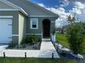 Welcoming front entrance features a walkway with landscape lighting and manicured planting beds at 1982 King Ranch St, Kissimmee, FL 34744