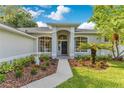 Charming front entrance with manicured landscaping, mature palms, and decorative garden art at 2024 Flaming Arrow Ct, Fern Park, FL 32730