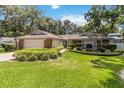 Charming single-story home with a well-manicured front yard, beautiful landscaping, and a welcoming entrance with a two-car garage at 205 Stevenage Dr, Longwood, FL 32779