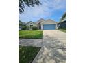 Well-manicured lawn complements this single-Gathering home with a spacious driveway and welcoming façade at 2817 Moultrie Creek Dr, Kissimmee, FL 34743