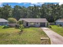 Charming single-story home featuring a well-maintained lawn and a long driveway leading to an attached garage at 3565 Sw Idlewild St, Dunnellon, FL 34431