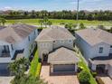 Aerial view of a suburban home with a paver driveway and lush green landscaping at 370 Pendant Ct, Kissimmee, FL 34747