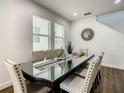 Bright dining room with a glass table, stylish chairs, and coastal decor at 370 Pendant Ct, Kissimmee, FL 34747