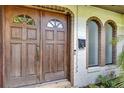 Close up of the wooden double front doors, brick trim, and a window box at 380 Violet Dell Dr, Casselberry, FL 32707