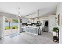 Bright kitchen with white cabinets, stainless steel appliances, island with seating, and sliding glass doors to backyard at 4478 Yachtmans Ct, Orlando, FL 32812