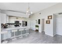 Bright kitchen with white cabinets, stainless steel appliances, an island with seating and modern light fixture at 4478 Yachtmans Ct, Orlando, FL 32812