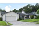 Inviting single-story home with brick paver driveway and well-maintained landscaping; the home features neutral exterior paint at 448 Stonewood Ln, Maitland, FL 32751