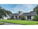 Classic single-story home with a lush green lawn and mature landscaping, neutral paint, and black shutters on the windows at 448 Stonewood Ln, Maitland, FL 32751