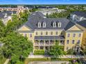 Overhead view of the three-story townhome with a second-story balcony, surrounded by lush greenery at 4584 Virginia Dr, Orlando, FL 32814