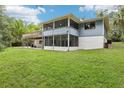 Expansive backyard with a deck, screened-in porch and lush lawn, perfect for outdoor gatherings at 5836 Spruce Creek Woods Dr, Port Orange, FL 32127