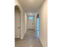 Bright hallway with tile flooring leading to the front door and rooms throughout the home at 613 Hickory Course Loop, Ocala, FL 34472