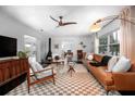 Bright living room featuring a leather sofa, fireplace, and view into the office at 627 N Cherokee Ave, Deland, FL 32724
