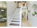 Bright foyer features tile flooring, staircase, and an arched alcove with decorative accents at 636 Milan Dr, Kissimmee, FL 34758