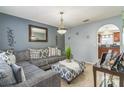 Comfortable living room with stylish gray sectional, patterned ottoman, and decorative lighting at 636 Milan Dr, Kissimmee, FL 34758