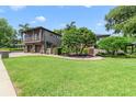 Expansive front yard with lush green lawn and mature trees framing the two-story house at 640 S Lake Formosa Dr, Orlando, FL 32803