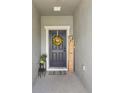 Welcoming front porch with decorative wreath, welcome sign, and potted plants at 785 Orchid Grove Blvd, Davenport, FL 33837