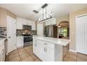 White kitchen with stainless appliances, island with quartz countertop and mosaic backsplash at 100 Monterey Oaks Dr, Sanford, FL 32771