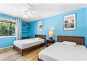 Bedroom featuring two beds, a built-in shelf, and bright blue painted walls at 1051 S Highland St # 7D, Mount Dora, FL 32757