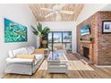 Bright living room with vaulted ceiling, brick fireplace, and sliding doors to balcony at 1051 S Highland St # 7D, Mount Dora, FL 32757