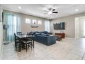 Comfortable living room and dining area with a large TV, tile floors, and open layout at 14460 Orchard Hills Blvd, Winter Garden, FL 34787