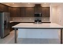Spacious kitchen with a large island, stainless steel appliances, and sleek dark cabinetry at 14568 Crestavista Ave, Clermont, FL 34714