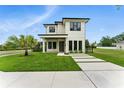 Modern two-story home with a well-manicured lawn, minimalist landscaping, and contrasting dark trim at 1733 Harmon Ave, Winter Park, FL 32789