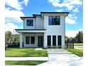 Modern two-story home boasting a clean white facade, black trim, manicured lawn, and contemporary landscaping at 1733 Harmon Ave, Winter Park, FL 32789