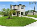 Modern two-story home with minimalist landscaping, a well-manicured lawn, and dark framed windows at 1733 Harmon Ave, Winter Park, FL 32789
